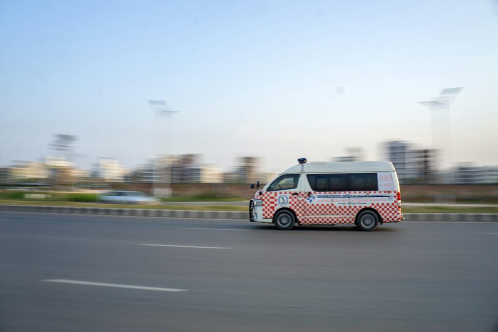 A white van is speeding down a city road.